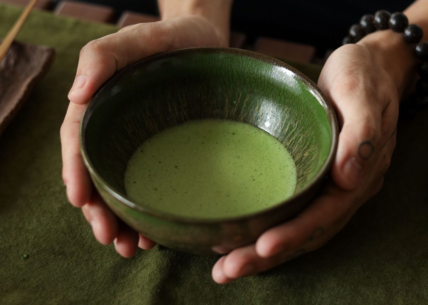 Đôi tay nâng chén matcha